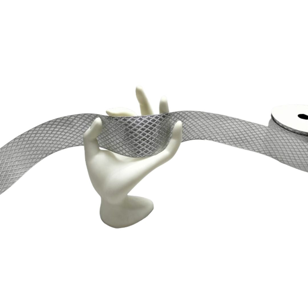 Mannequin hand holding a roll of silver mesh ribbon on a white background